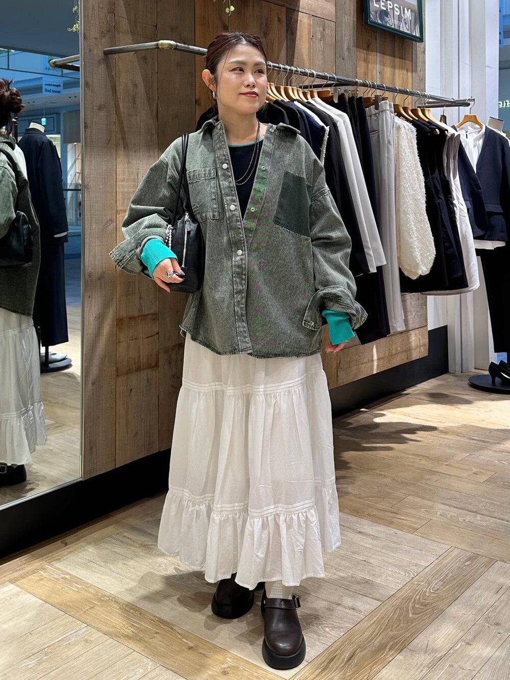 ブラウン系のサンダル、グリーン系のシャツ/ブラウス、ブラック系のボストンバッグを着用したレディースの冬コーディネートの7枚目の写真