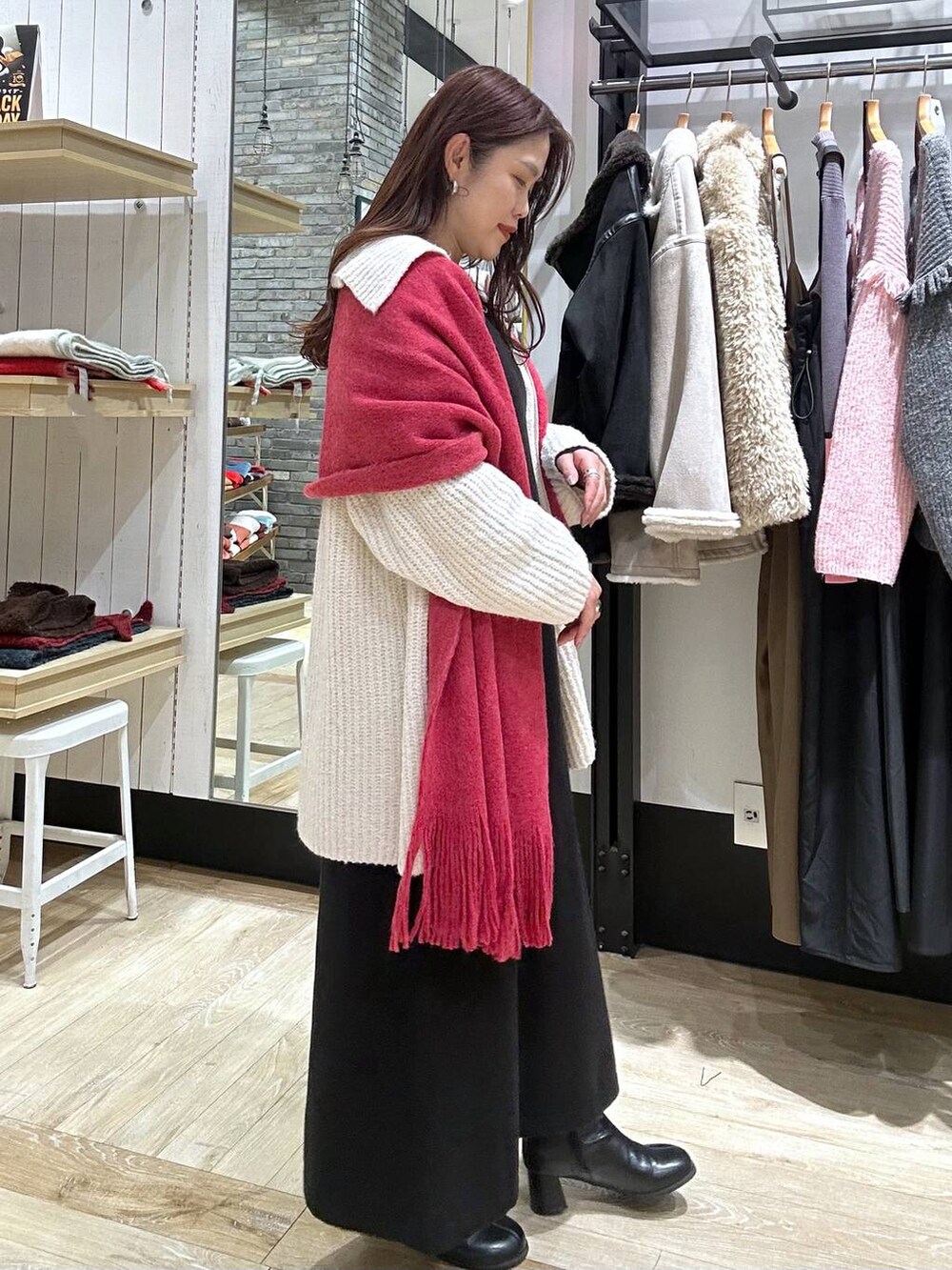 ブラック系のブーツ、ブラック系のショルダーバッグ、ブラック系のワンピースを着用したレディースの秋コーディネートの3枚目の写真