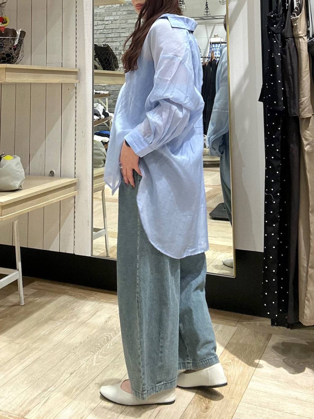 ブルー系のシャツ/ブラウス、ホワイト系のパンプス、ブルー系のデニムパンツを着用したレディースの春コーディネートの2枚目の写真