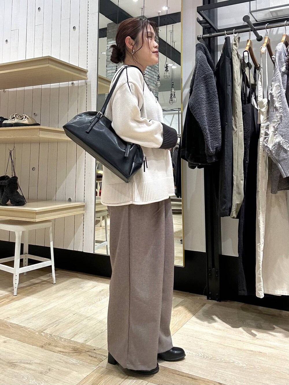 ブラック系のボストンバッグ、ブラック系のブーツ、ブラウン系のその他パンツを着用したレディースの冬コーディネートの2枚目の写真