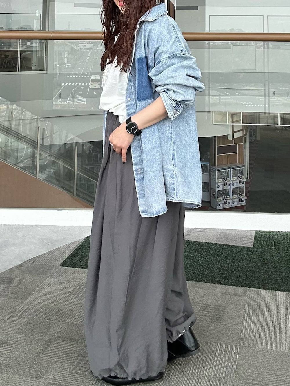 ブルー系のシャツ/ブラウス、ブラック系のパンプス、ホワイト系のTシャツ/カットソーを着用したレディースの春コーディネートの4枚目の写真