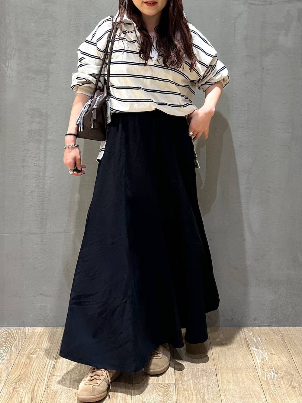 ブラウン系のボストンバッグ、ブラック系のスカート、ブラック系のキャップを着用したレディースの冬コーディネートの6枚目の写真