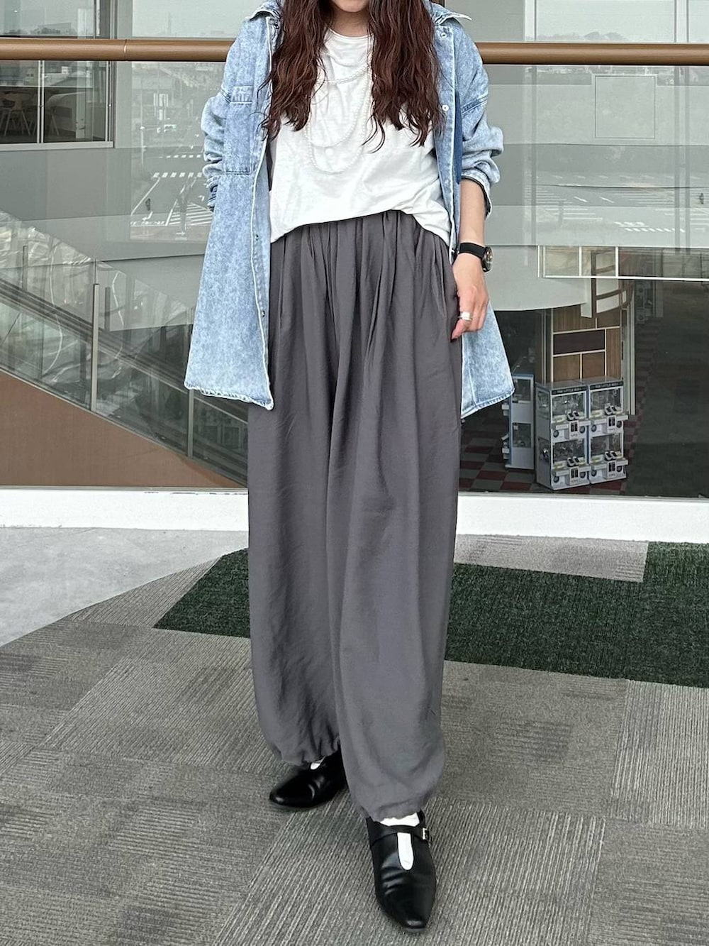 ブルー系のシャツ/ブラウス、ブラック系のパンプス、ホワイト系のTシャツ/カットソーを着用したレディースの春コーディネートの6枚目の写真