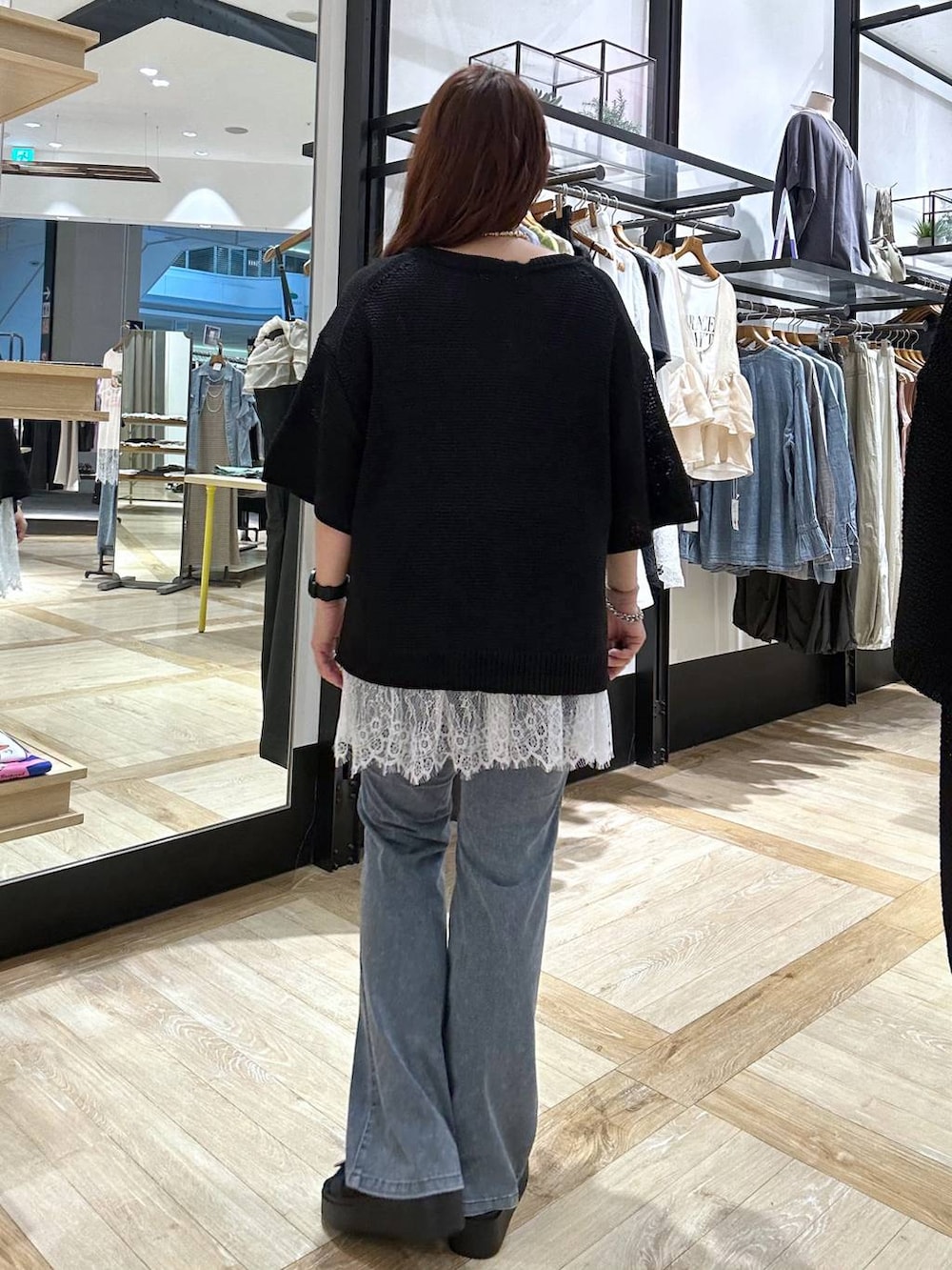 ホワイト系のキャミソール、ブラック系のサンダル、ブルー系のデニムパンツを着用したレディースの夏コーディネートの3枚目の写真