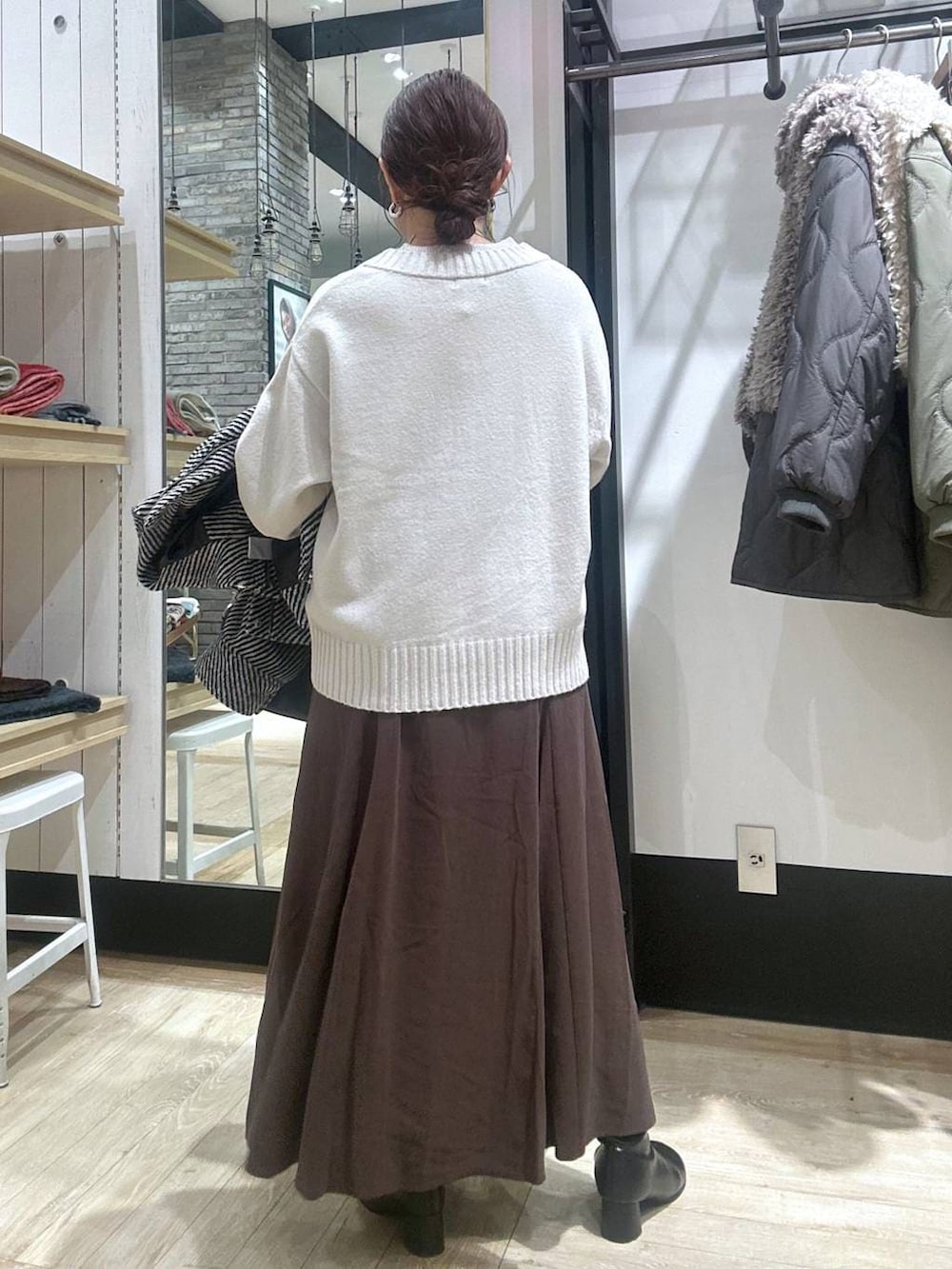 ブラック系のショルダーバッグ、ホワイト系のニット/セーター、ブラック系のブルゾンを着用したレディースの冬コーディネートの5枚目の写真