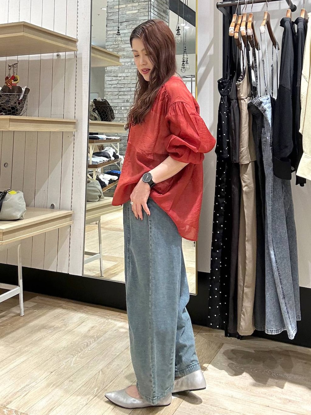 シルバー系のパンプス、レッド系のシャツ/ブラウス、ブラック系のショルダーバッグを着用したレディースの春コーディネートの2枚目の写真