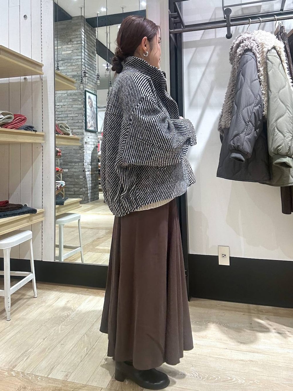 ブラック系のショルダーバッグ、ホワイト系のニット/セーター、ブラック系のブルゾンを着用したレディースの冬コーディネートの4枚目の写真