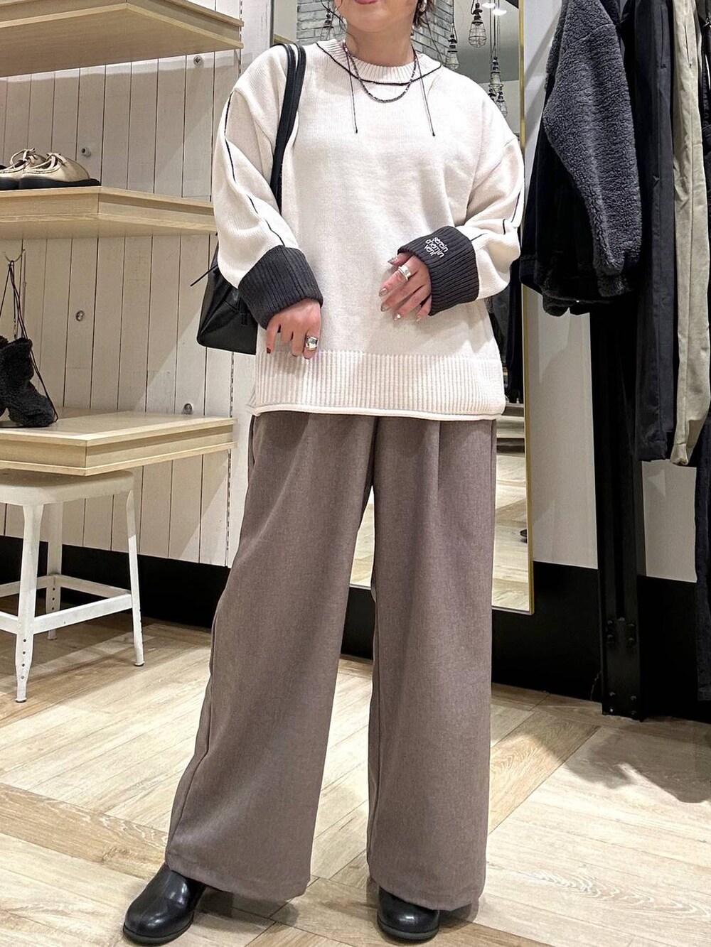 ブラック系のボストンバッグ、ブラック系のブーツ、ブラウン系のその他パンツを着用したレディースの冬コーディネートの4枚目の写真