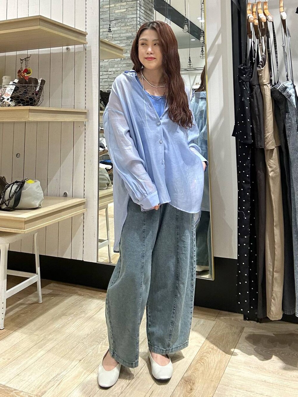 ブルー系のシャツ/ブラウス、ホワイト系のパンプス、ブルー系のデニムパンツを着用したレディースの春コーディネートの7枚目の写真