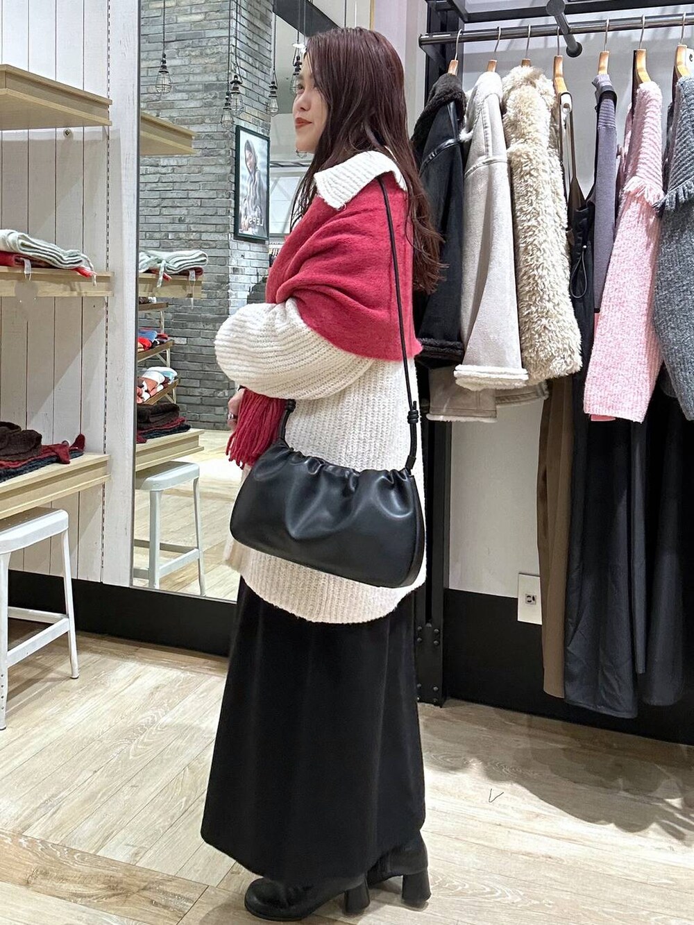 ブラック系のブーツ、ブラック系のショルダーバッグ、ブラック系のワンピースを着用したレディースの秋コーディネートの2枚目の写真