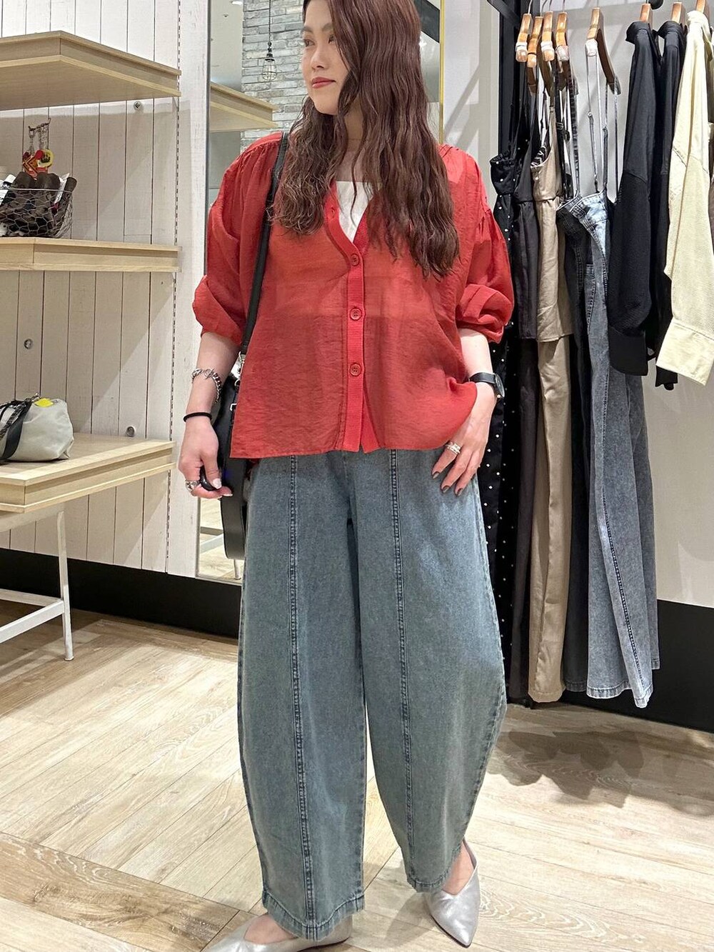 シルバー系のパンプス、レッド系のシャツ/ブラウス、ブラック系のショルダーバッグを着用したレディースの春コーディネートの6枚目の写真