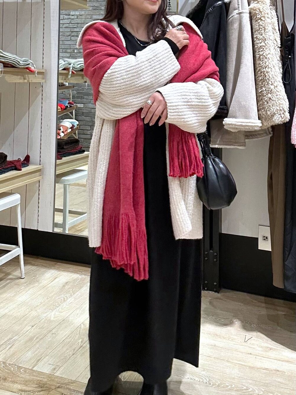 ブラック系のブーツ、ブラック系のショルダーバッグ、ブラック系のワンピースを着用したレディースの秋コーディネートの4枚目の写真