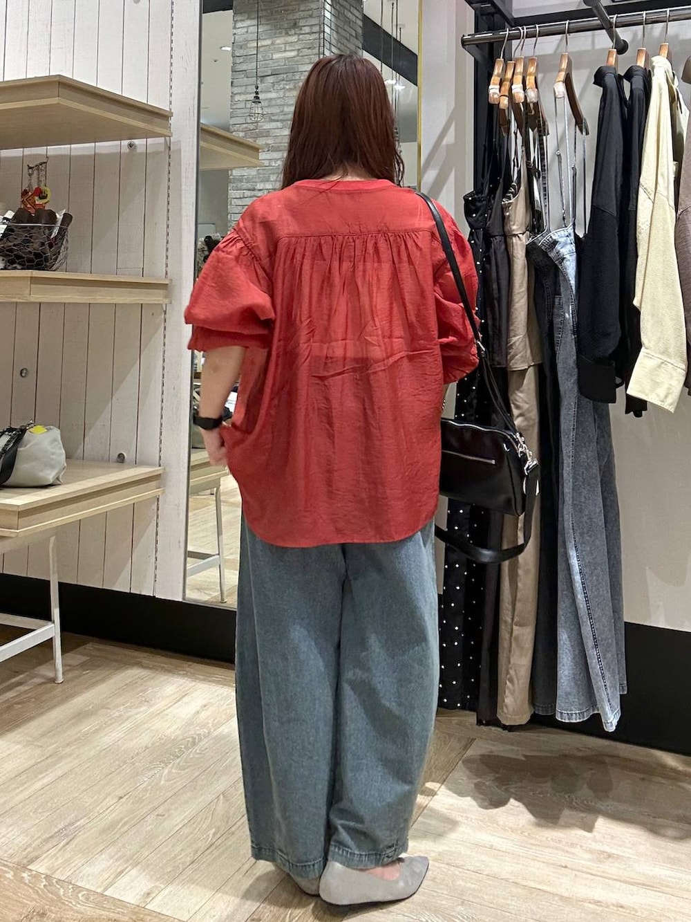 シルバー系のパンプス、レッド系のシャツ/ブラウス、ブラック系のショルダーバッグを着用したレディースの春コーディネートの3枚目の写真