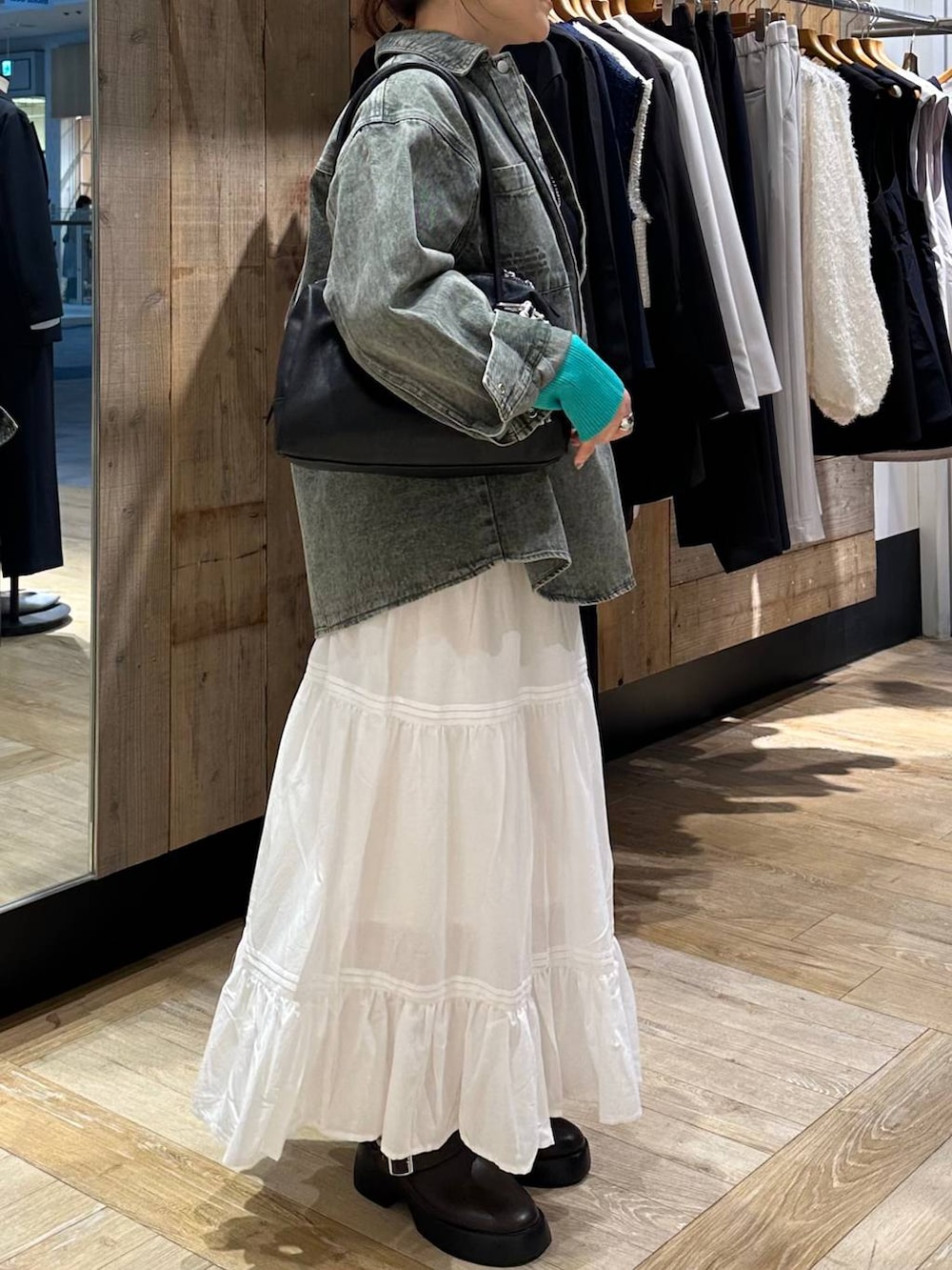 ブラウン系のサンダル、グリーン系のシャツ/ブラウス、ブラック系のボストンバッグを着用したレディースの冬コーディネートの2枚目の写真