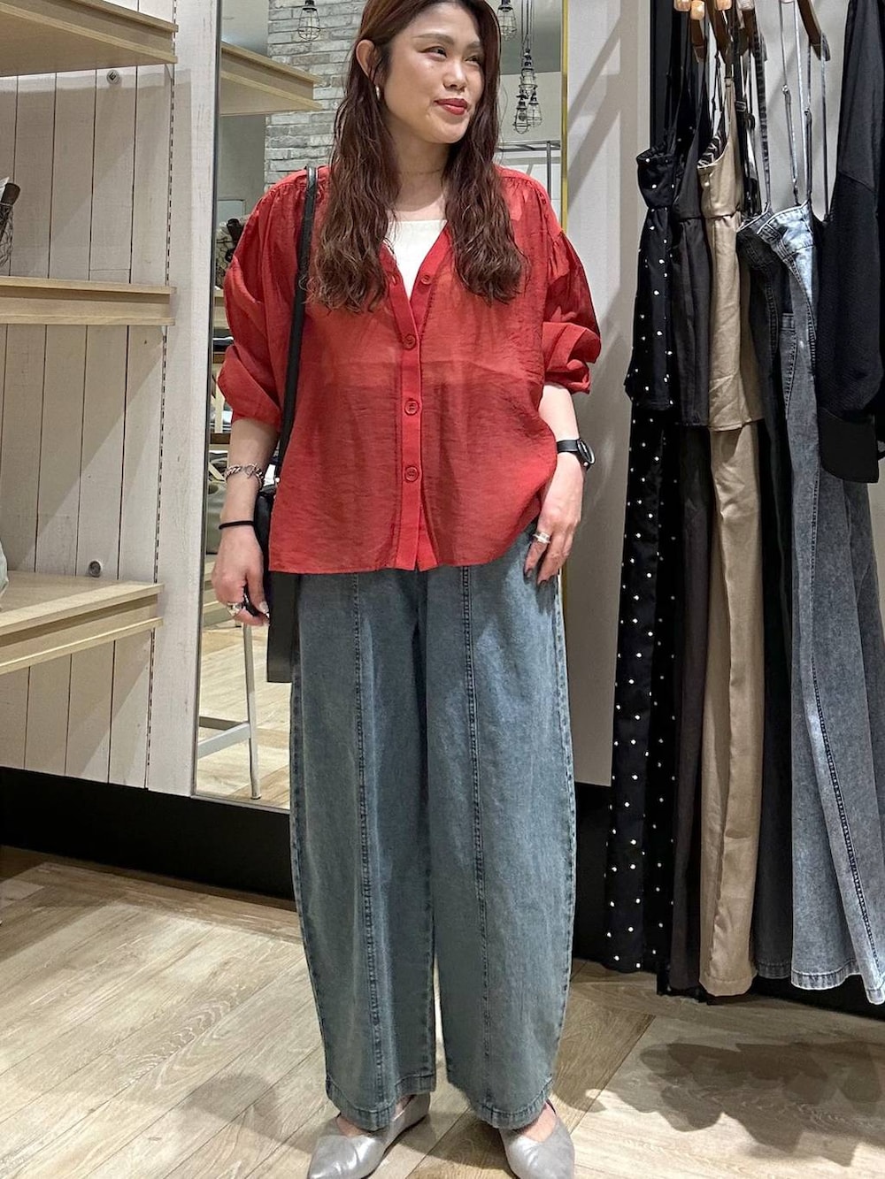 シルバー系のパンプス、レッド系のシャツ/ブラウス、ブラック系のショルダーバッグを着用したレディースの春コーディネートの7枚目の写真