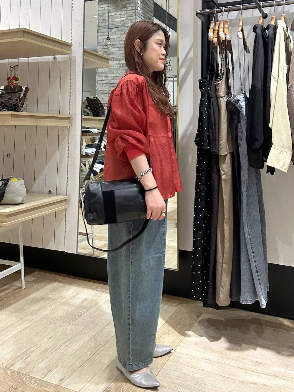 シルバー系のパンプス、レッド系のシャツ/ブラウス、ブラック系のショルダーバッグを着用したレディースの春コーディネートの4枚目の写真