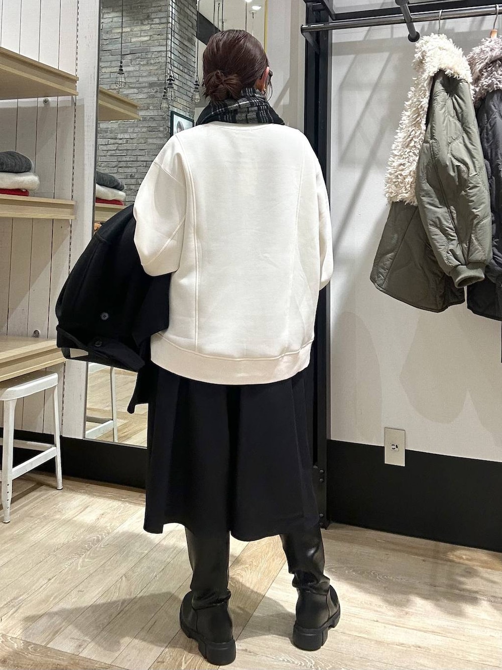 ブラック系のその他アウター、ブラック系のボストンバッグ、ブラック系のブーツを着用したレディースの冬コーディネートの4枚目の写真