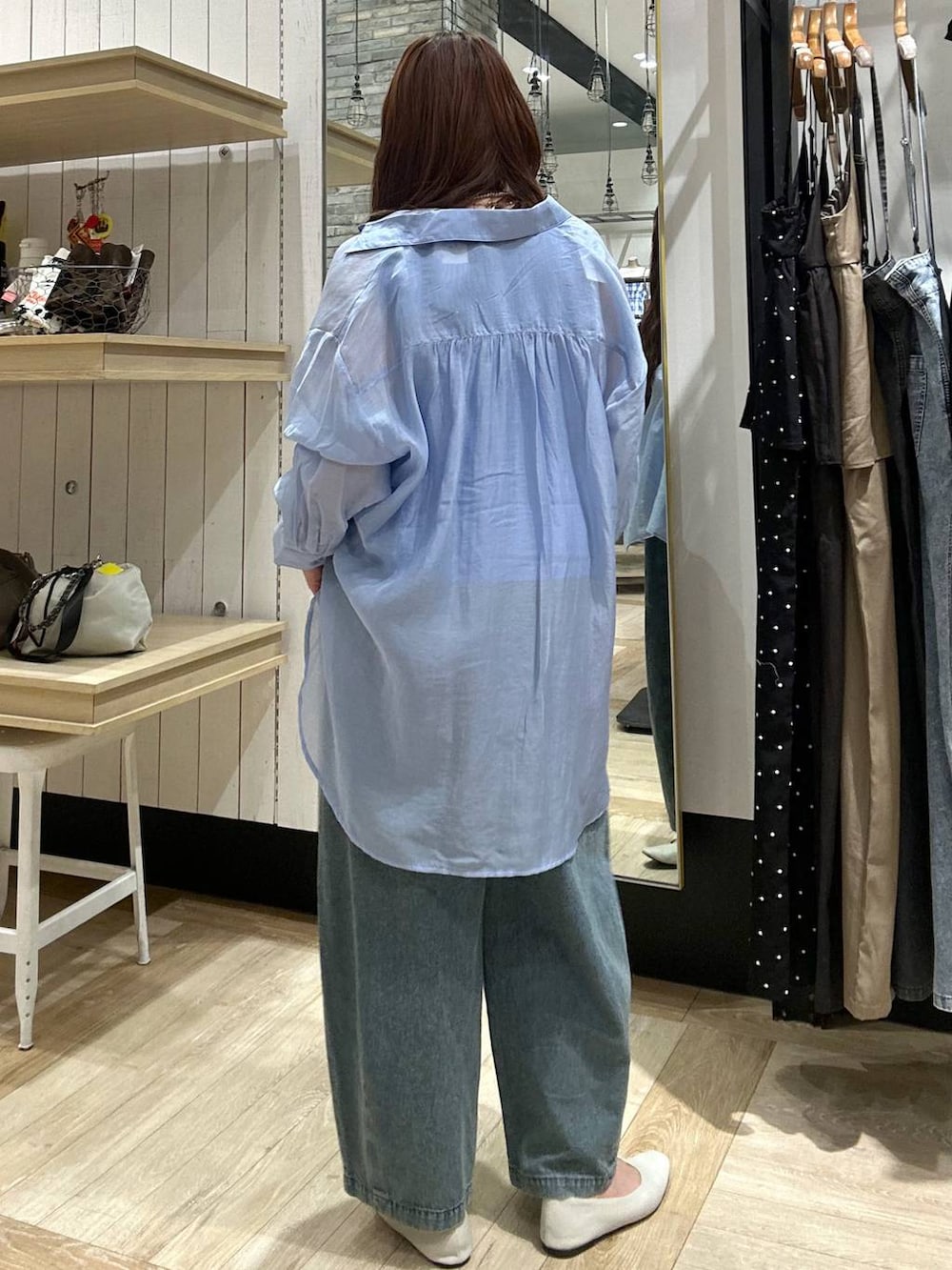 ブルー系のシャツ/ブラウス、ホワイト系のパンプス、ブルー系のデニムパンツを着用したレディースの春コーディネートの3枚目の写真