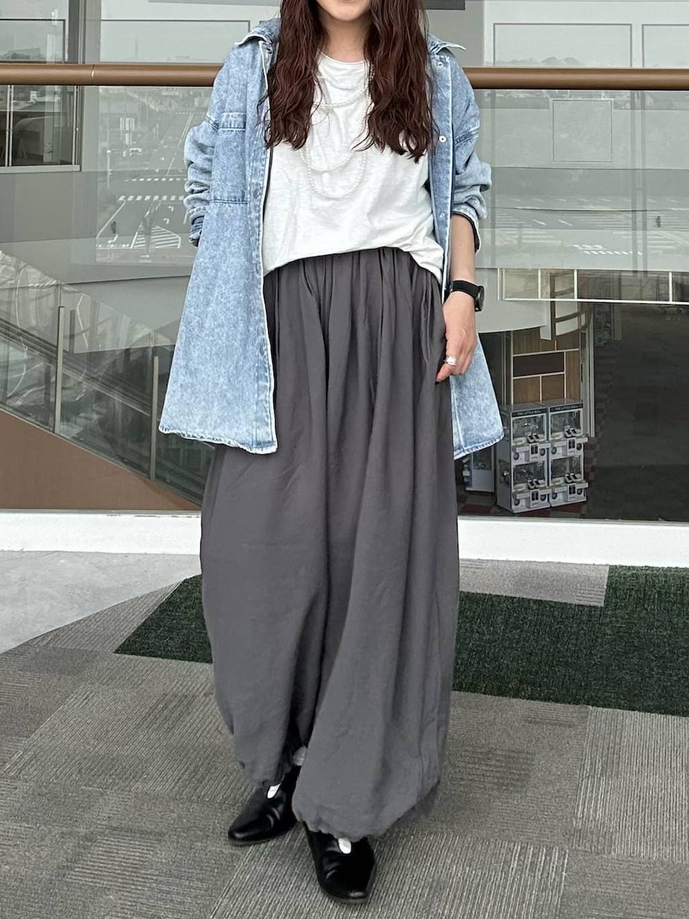 ブルー系のシャツ/ブラウス、ブラック系のパンプス、ホワイト系のTシャツ/カットソーを着用したレディースの春コーディネートの5枚目の写真