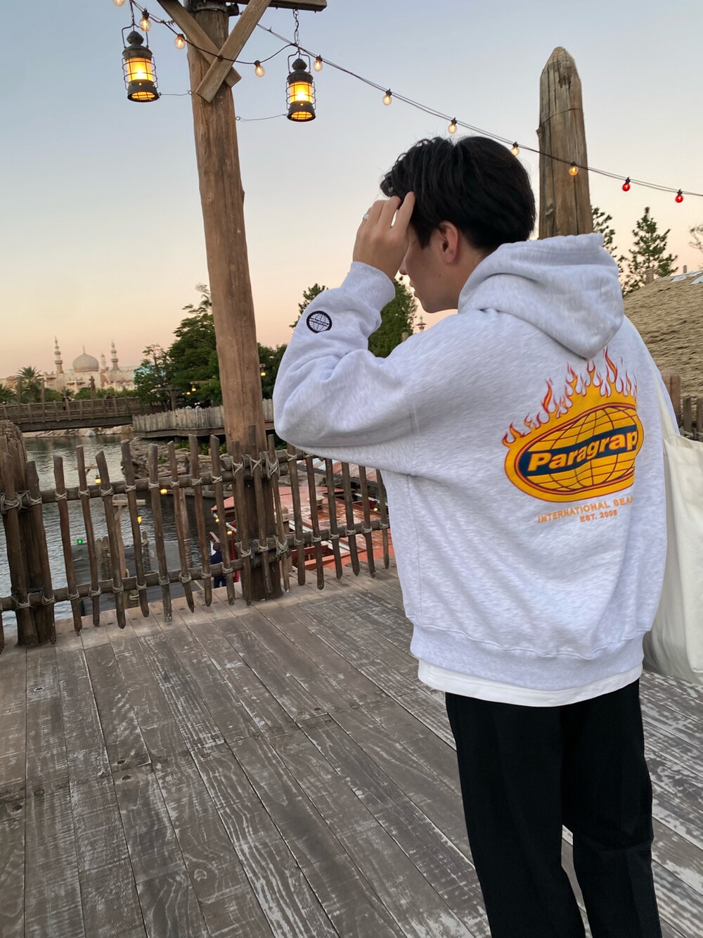 ブラック系のスラックス、ホワイト系のスニーカー、ホワイト系のパーカーを着用したメンズの秋コーディネートの2枚目の写真