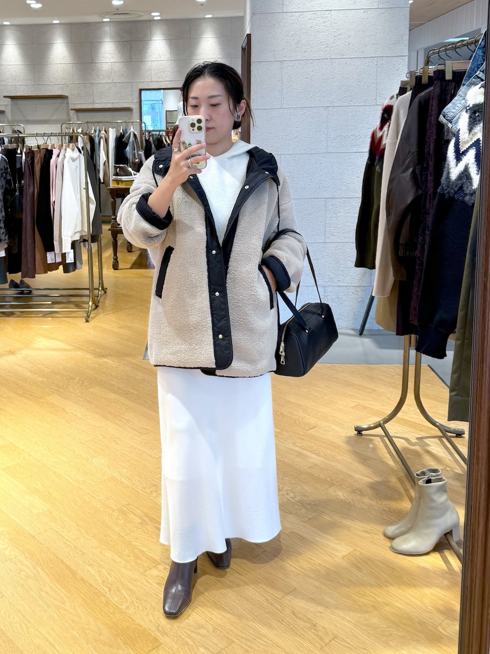 ホワイト系のニット/セーター、ベージュ系のその他アウター、ホワイト系のスカートを着用したレディースの秋コーディネートの2枚目の写真