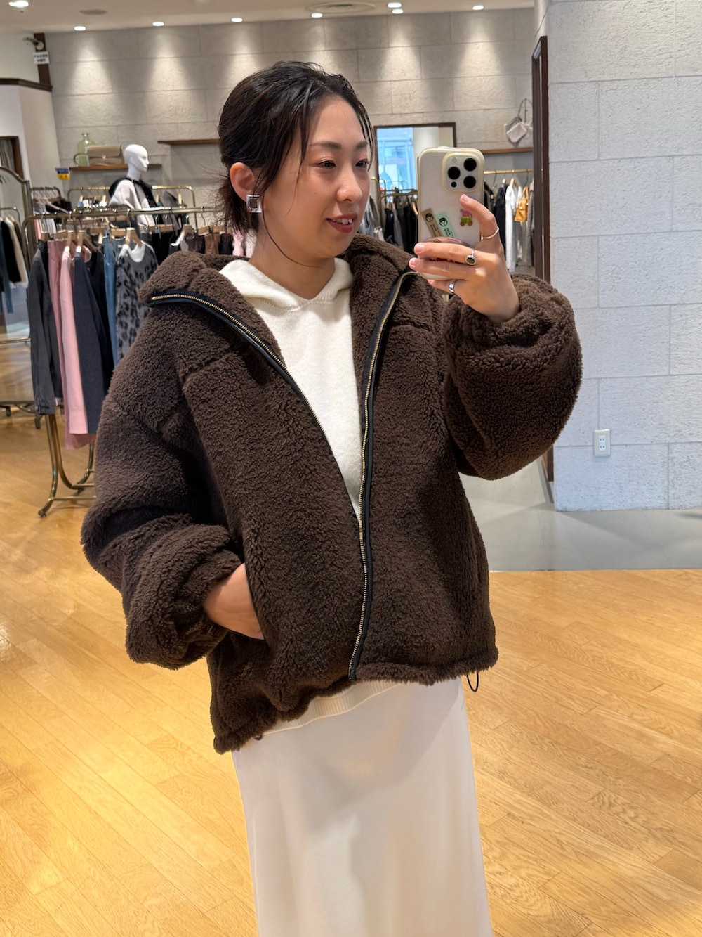 ブラウン系のその他アウター、ホワイト系のニット/セーター、ホワイト系のスカートを着用したレディースの秋コーディネートの3枚目の写真