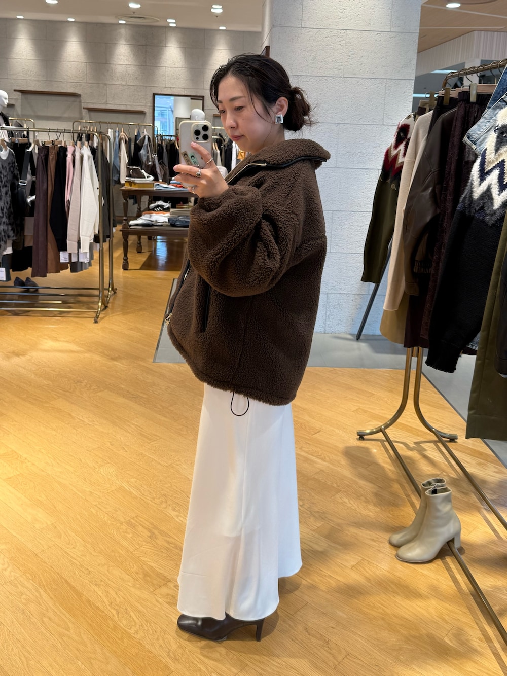 ブラウン系のその他アウター、ホワイト系のニット/セーター、ホワイト系のスカートを着用したレディースの秋コーディネートの2枚目の写真