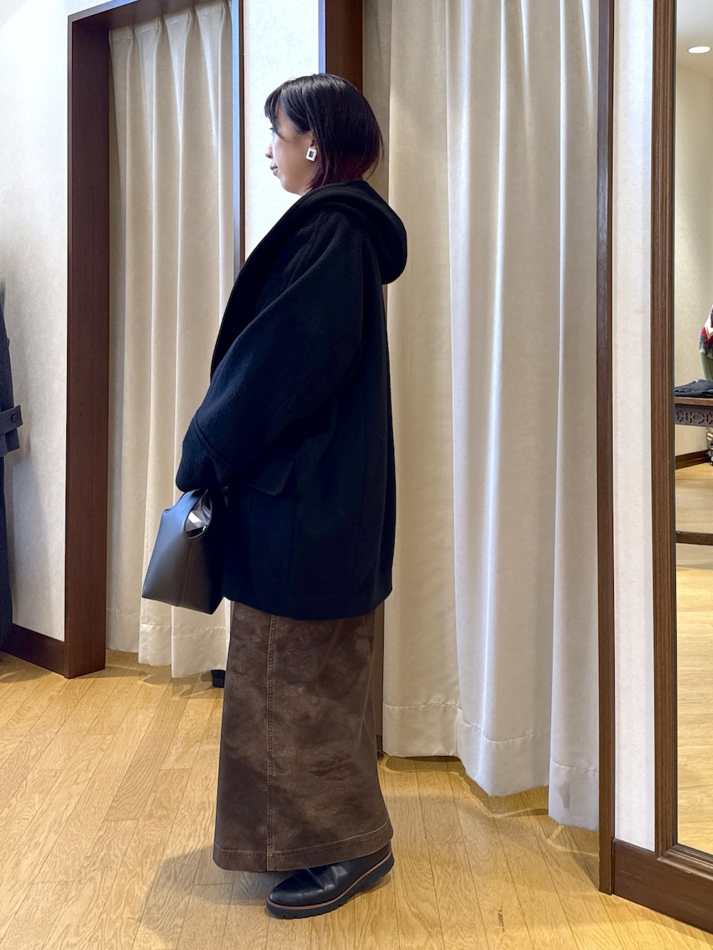 ブラック系のその他アウター、ブラウン系のスウェット、ホワイト系のTシャツ/カットソーを着用したレディースの秋コーディネートの3枚目の写真