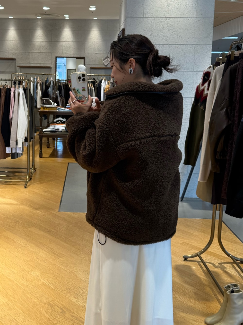 ブラウン系のその他アウター、ホワイト系のニット/セーター、ホワイト系のスカートを着用したレディースの秋コーディネートの4枚目の写真