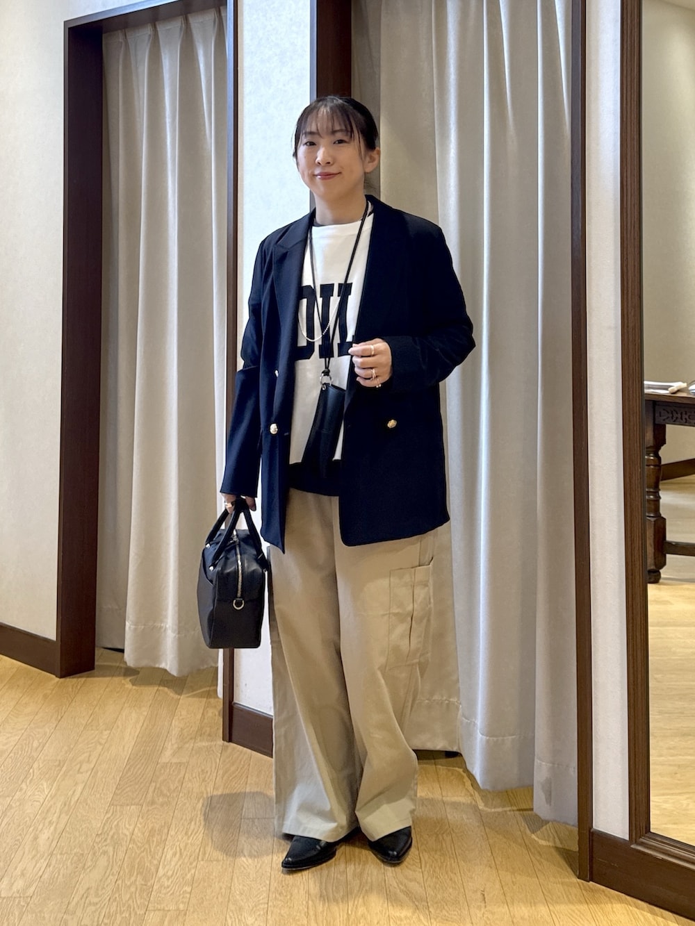 ブルー系のテーラードジャケット、ホワイト系のスウェット、ブラック系のボストンバッグを着用したレディースの春コーディネートの3枚目の写真