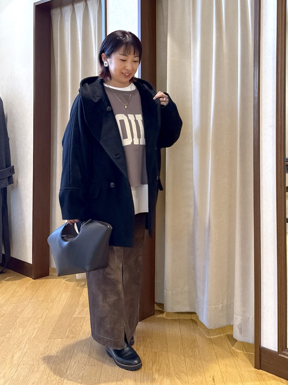 ブラック系のその他アウター、ブラウン系のスウェット、ホワイト系のTシャツ/カットソーを着用したレディースの秋コーディネートの5枚目の写真