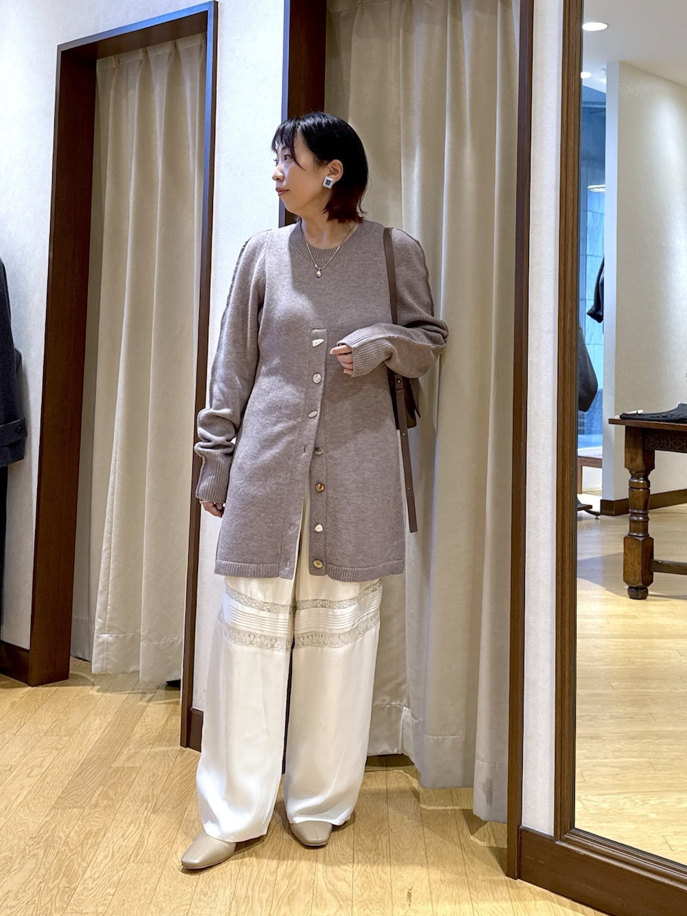 ベージュ系のニット/セーター、ブラウン系のショルダーバッグ、ホワイト系のその他パンツを着用したレディースの秋コーディネートの4枚目の写真