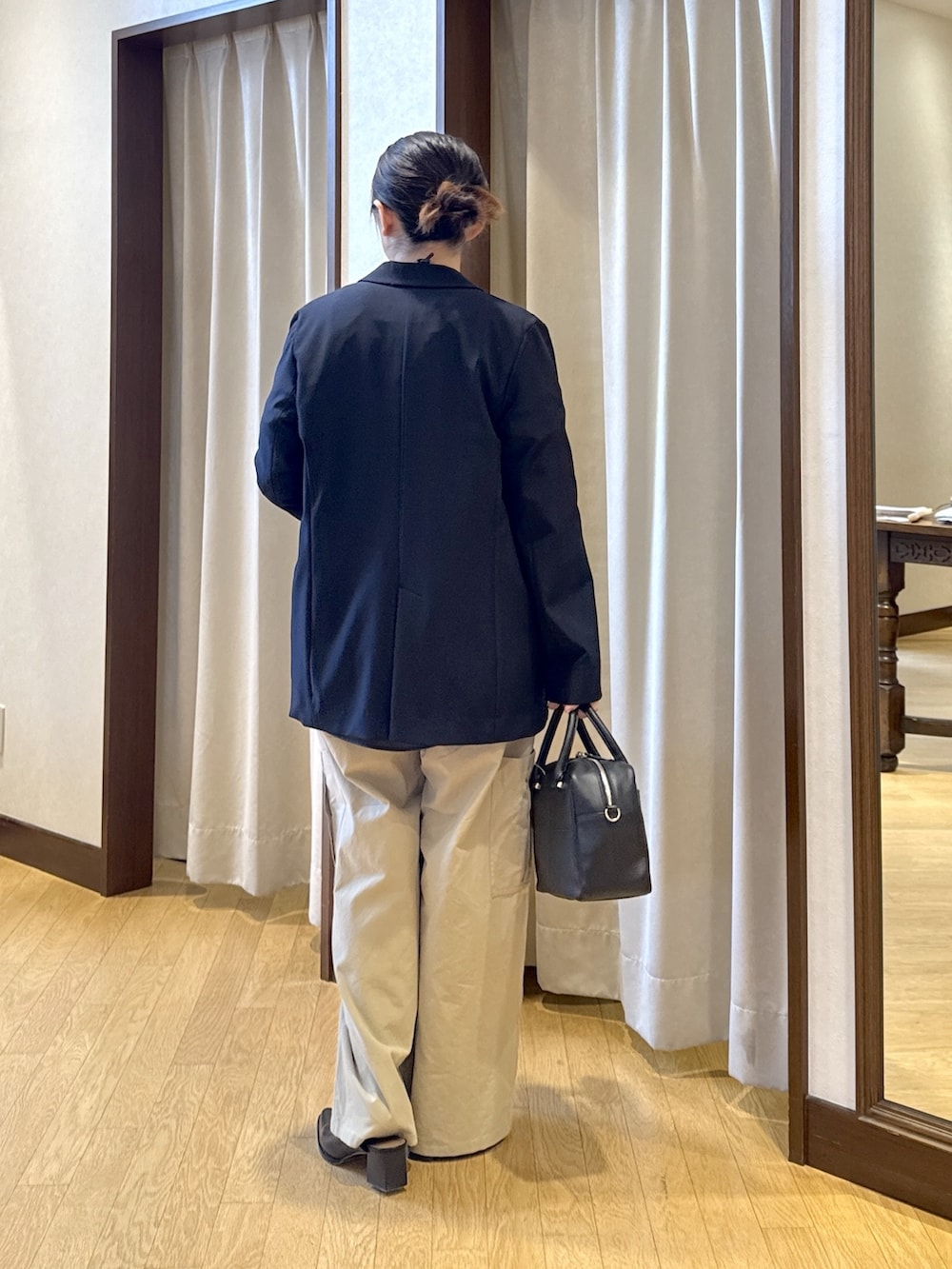 ブルー系のテーラードジャケット、ホワイト系のスウェット、ブラック系のボストンバッグを着用したレディースの春コーディネートの4枚目の写真