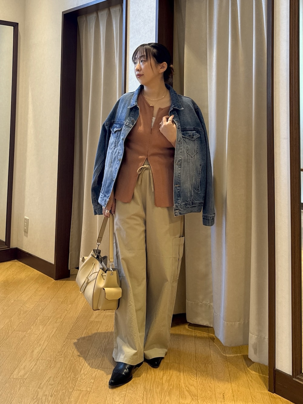 オレンジ系のカーディガン/ボレロ、ベージュ系のショルダーバッグ、ベージュ系のカーゴパンツを着用したレディースの春コーディネートの2枚目の写真