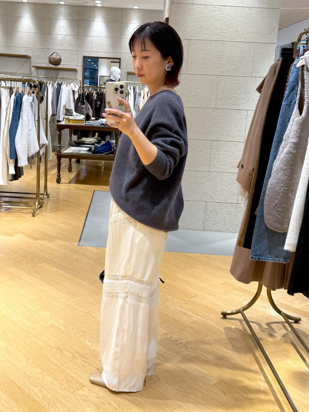 グレー系のニット/セーター、ホワイト系のその他パンツ、ブラック系のハンドバッグを着用したレディースの冬コーディネートの2枚目の写真