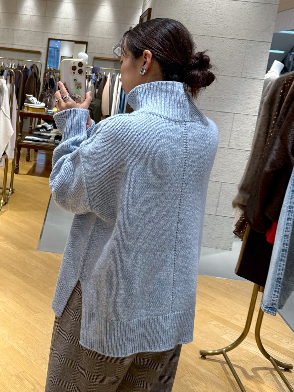 ホワイト系のニット/セーター、ブラウン系のスラックス、ブラック系のブーツを着用したレディースの秋コーディネートの3枚目の写真