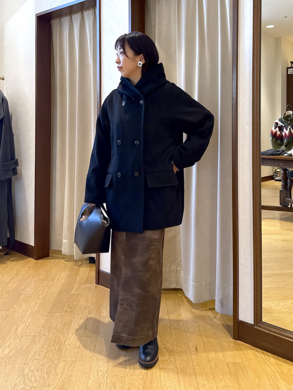 ブラック系のその他アウター、ブラウン系のスウェット、ホワイト系のTシャツ/カットソーを着用したレディースの秋コーディネートの2枚目の写真