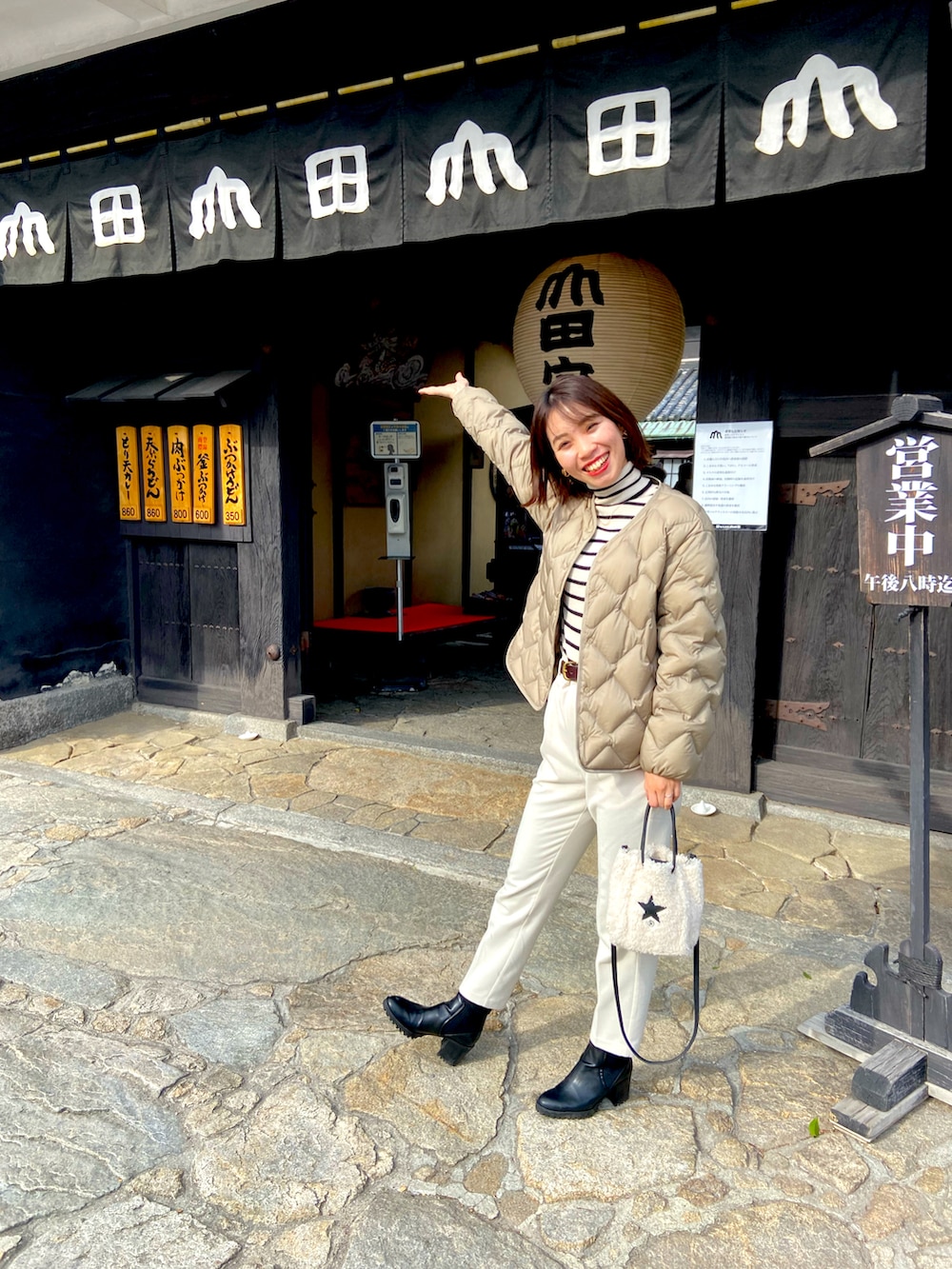 ホワイト系のパンツ、ブルー系のニット/セーター、ホワイト系のショルダーバッグを着用したレディースの冬コーディネートの2枚目の写真