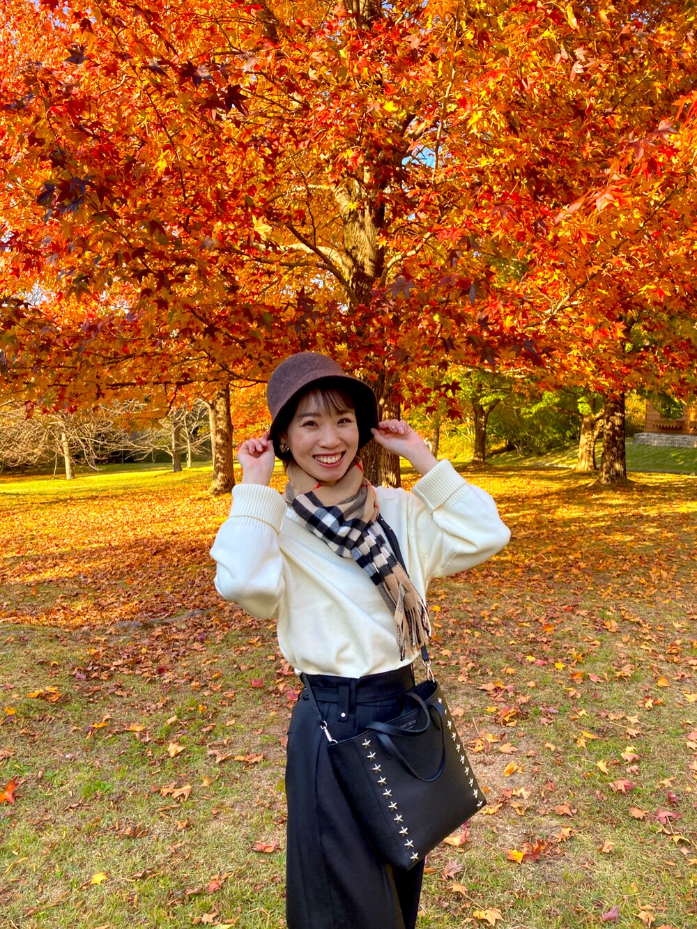 ホワイト系のニット/セーター、ブラック系のスラックス、ブラウン系のハットを着用したレディースの冬コーディネートの2枚目の写真