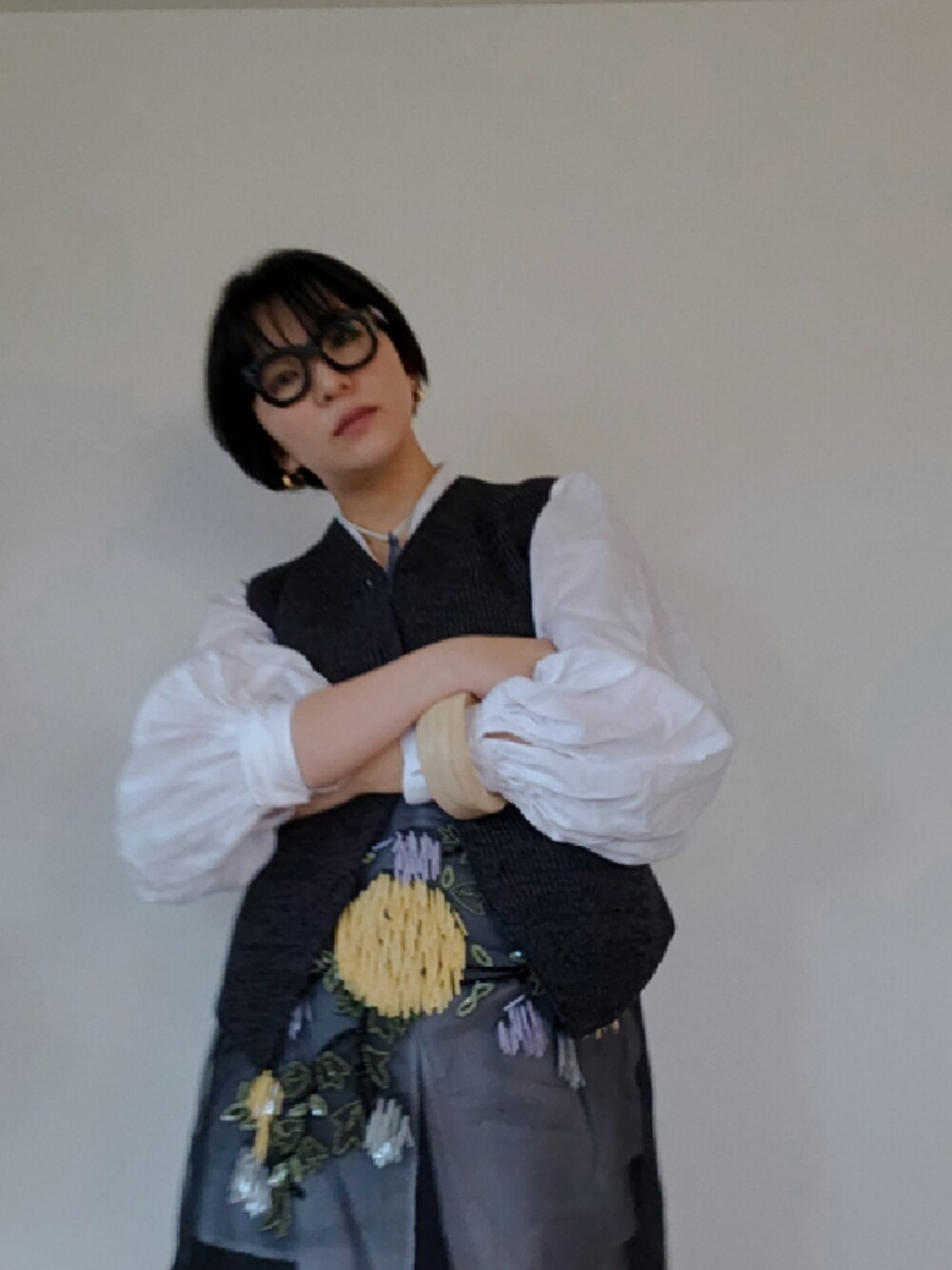 ブラック系のスカート、グレー系のベスト、ベージュ系のブレスレットを着用したレディースの春コーディネートの3枚目の写真