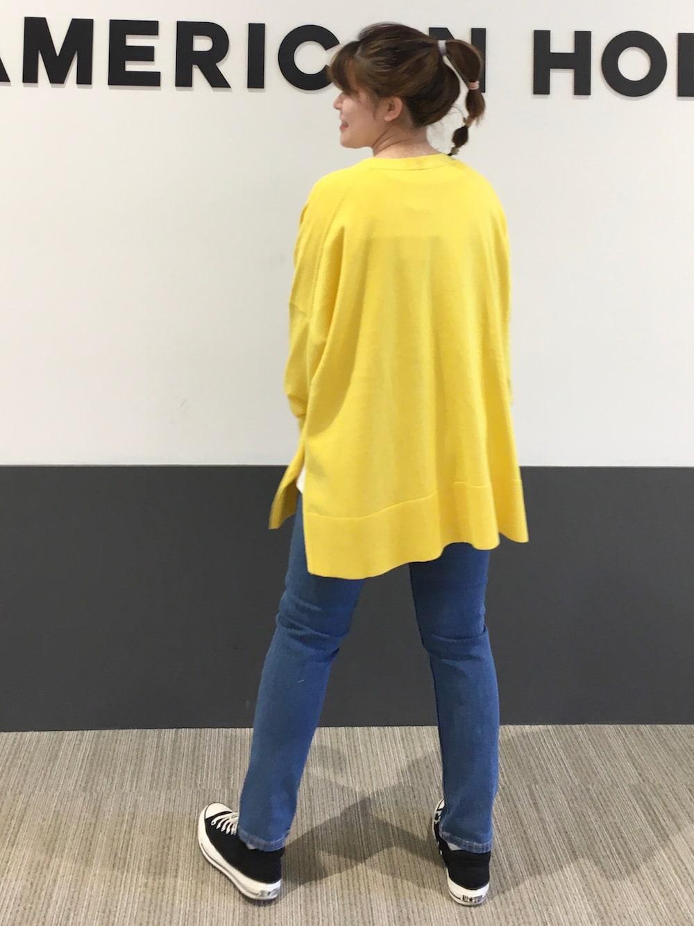 イエロー系のカーディガン/ボレロ、ブラック系のスニーカー、ホワイト系のTシャツ/カットソーを着用したレディースの春コーディネートの3枚目の写真