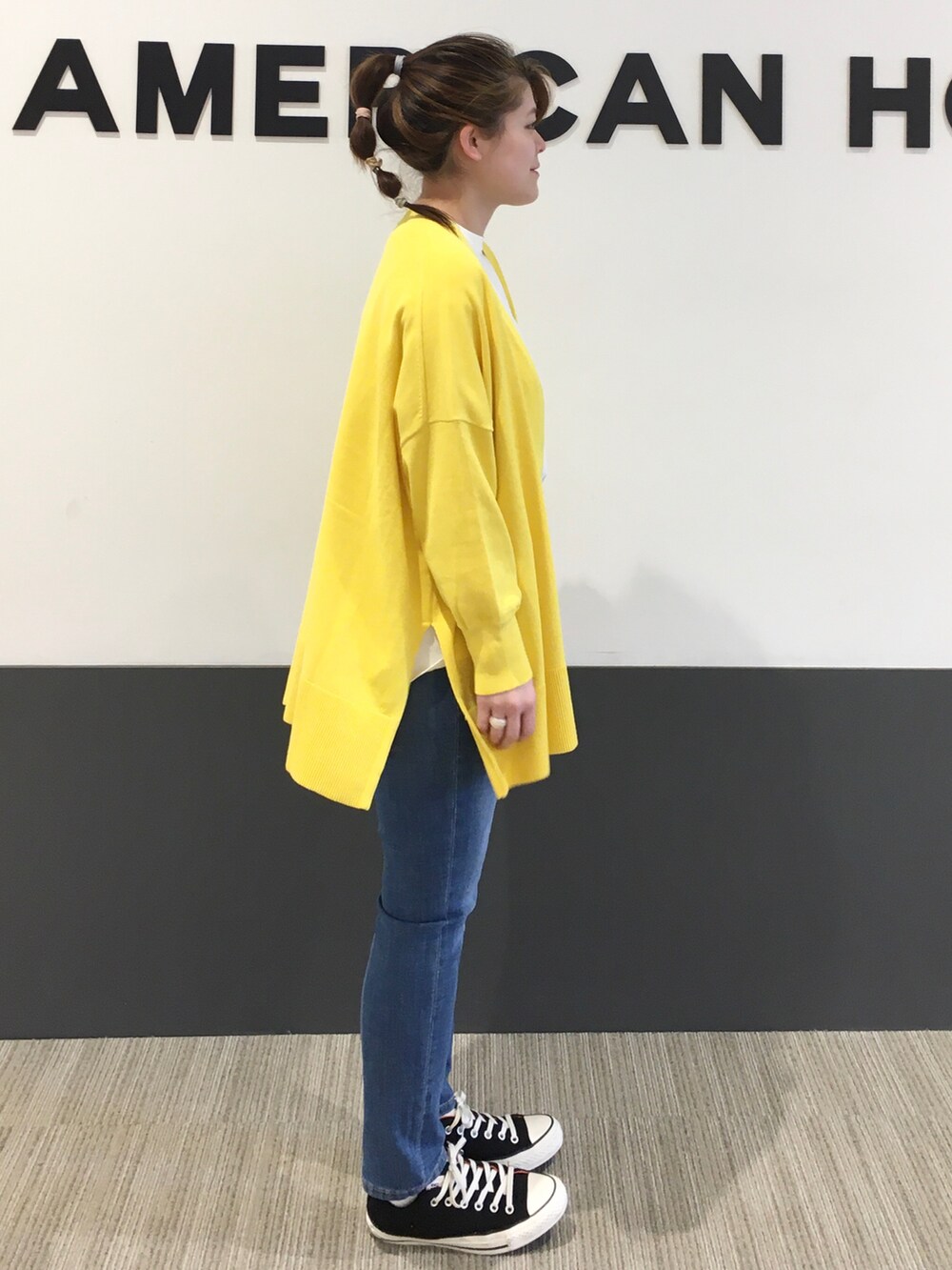 イエロー系のカーディガン/ボレロ、ブラック系のスニーカー、ホワイト系のTシャツ/カットソーを着用したレディースの春コーディネートの2枚目の写真