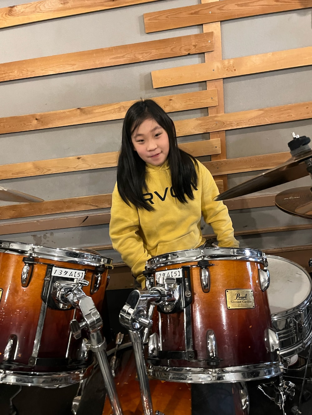 イエロー系のパーカー、ブラック系のスタジャン、レッド系のスニーカーを着用したキッズの冬コーディネートの2枚目の写真