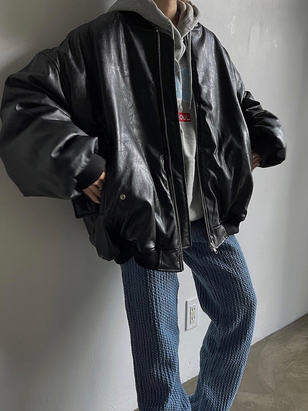 ブラック系のMA-1、ブルー系のパンツ、ホワイト系のスニーカーを着用したレディースの冬コーディネートの3枚目の写真