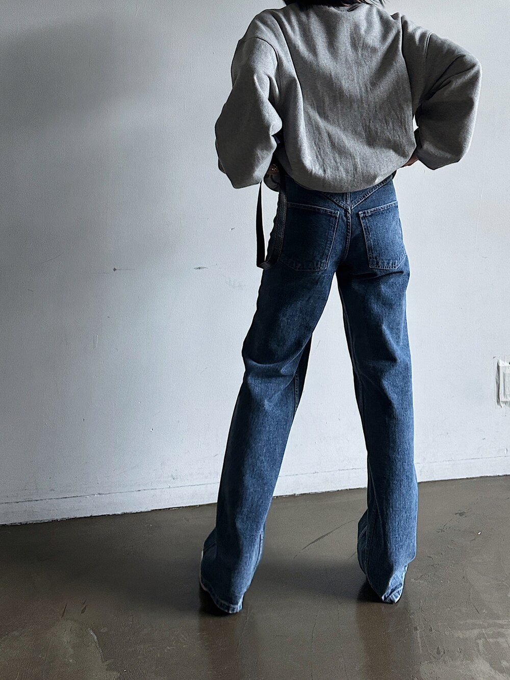 ブルー系のデニムパンツ、グレー系のスウェットを着用したレディースの春コーディネートの2枚目の写真