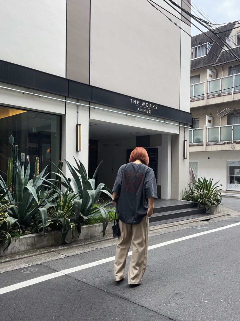 ブラック系のTシャツ/カットソー、ベージュ系のパンツ、ベージュ系のシューズを着用したレディースの秋コーディネートの4枚目の写真