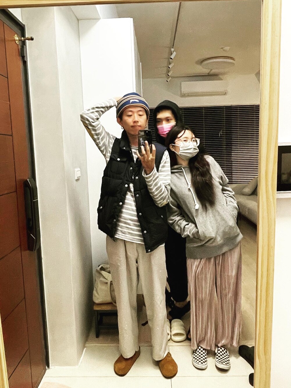 ホワイト系のチノパンツ、ブルー系のダウンベスト、グレー系のトップスを着用したメンズの冬コーディネートの2枚目の写真