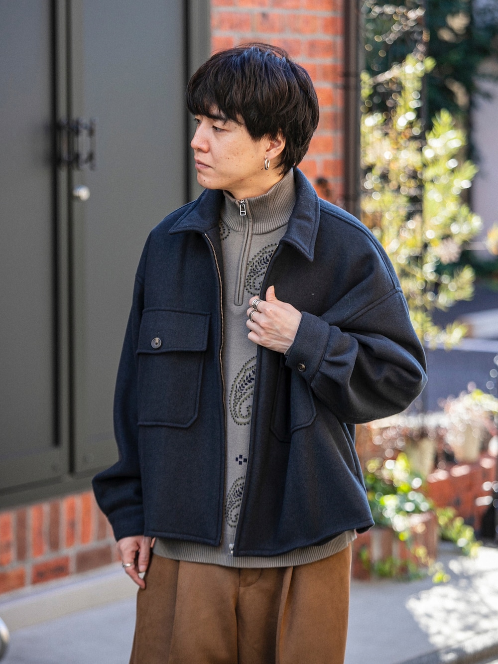 ブラック系のブルゾン、ベージュ系のニット/セーター、ベージュ系のその他パンツを着用したメンズの冬コーディネートの4枚目の写真