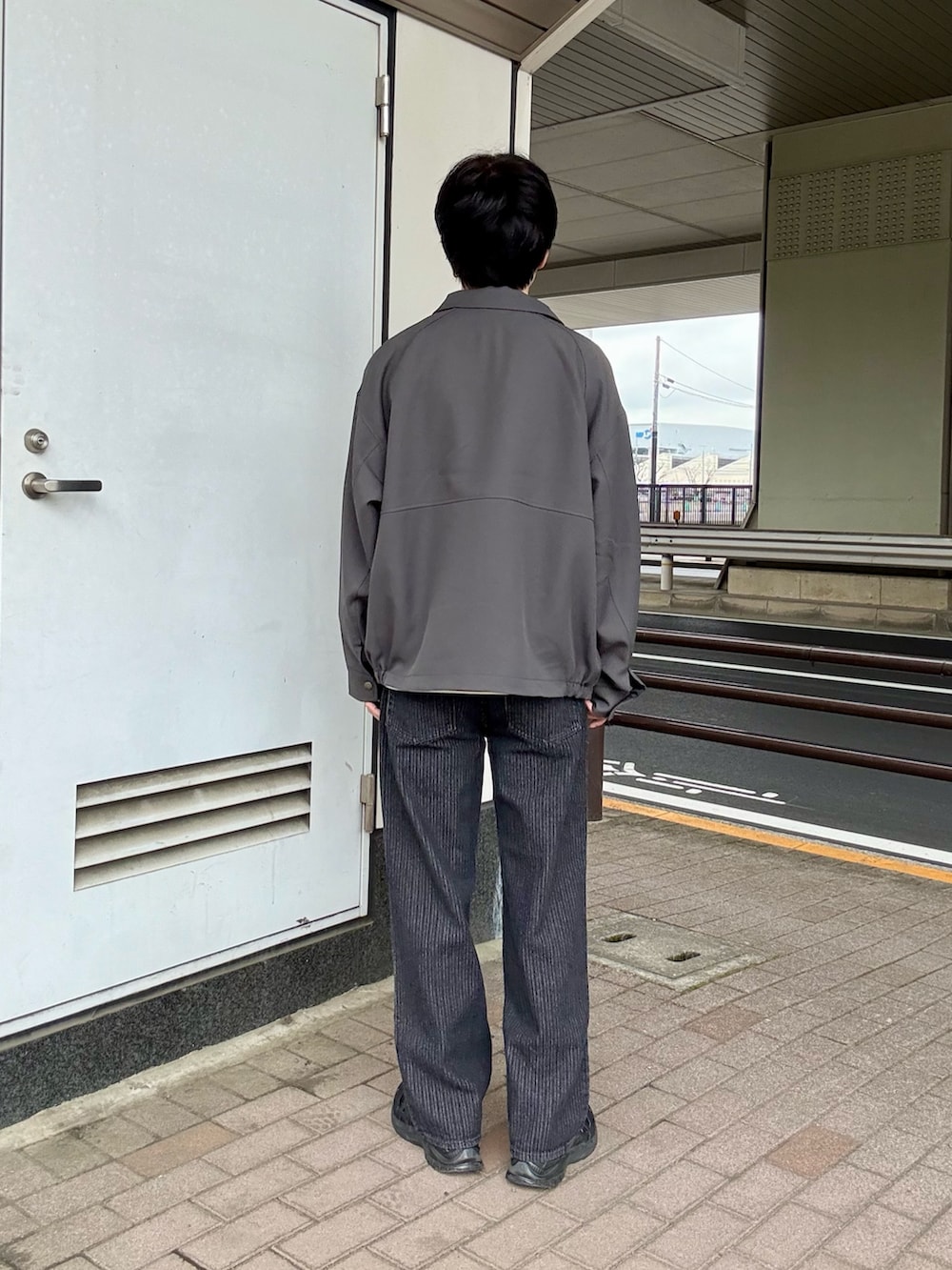 ブルー系のブルゾン、ブラック系のその他パンツ、ホワイト系のTシャツ/カットソーを着用したメンズの春コーディネートの3枚目の写真