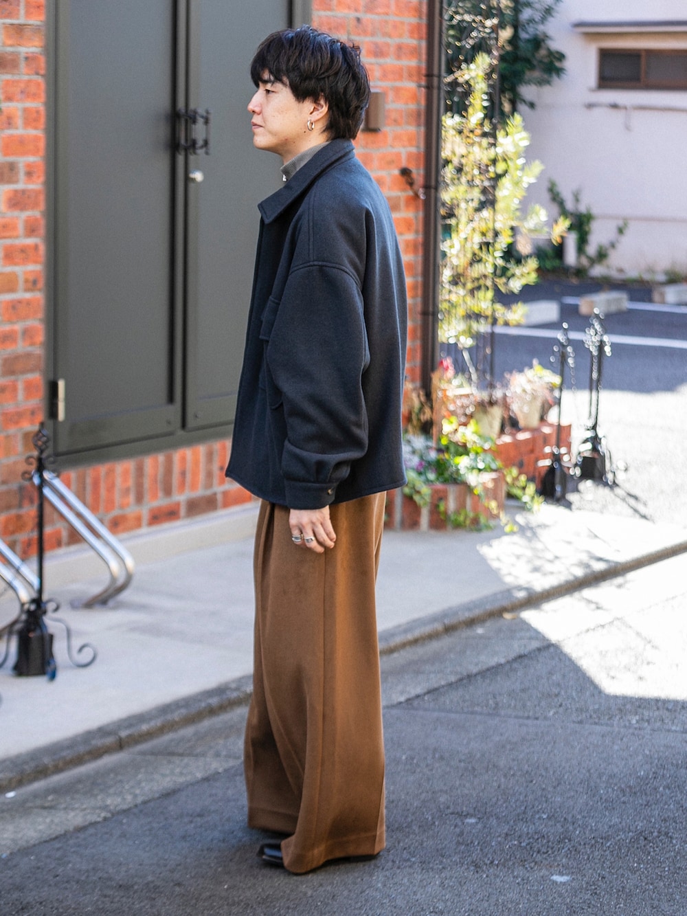 ブラック系のブルゾン、ベージュ系のニット/セーター、ベージュ系のその他パンツを着用したメンズの冬コーディネートの2枚目の写真